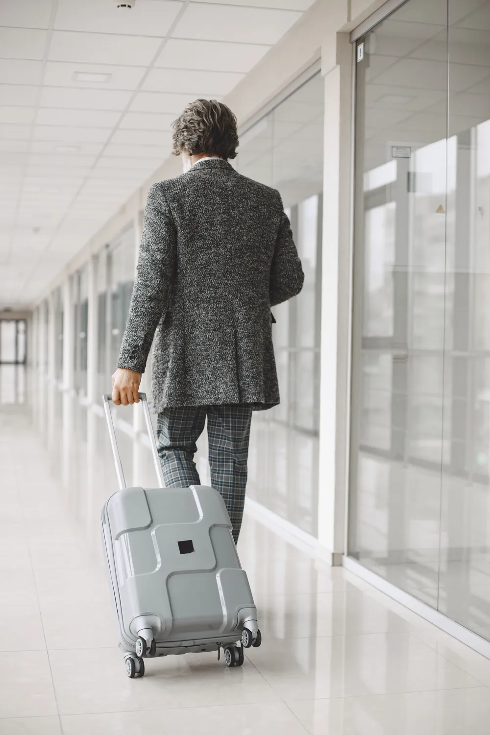 On-board courier with case in an airport corridor